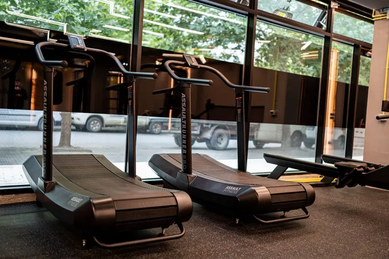 Two curved treadmills by the street-side windows