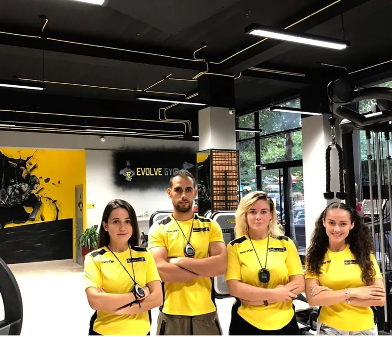 Four Evolve trainers in yellow team shirts on the gym floor