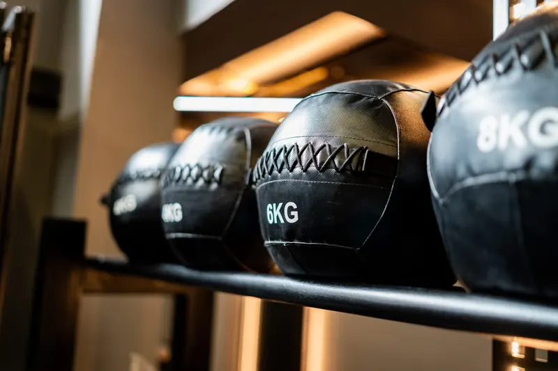 Medicine balls of 6 and 8 kg lined up on a rack